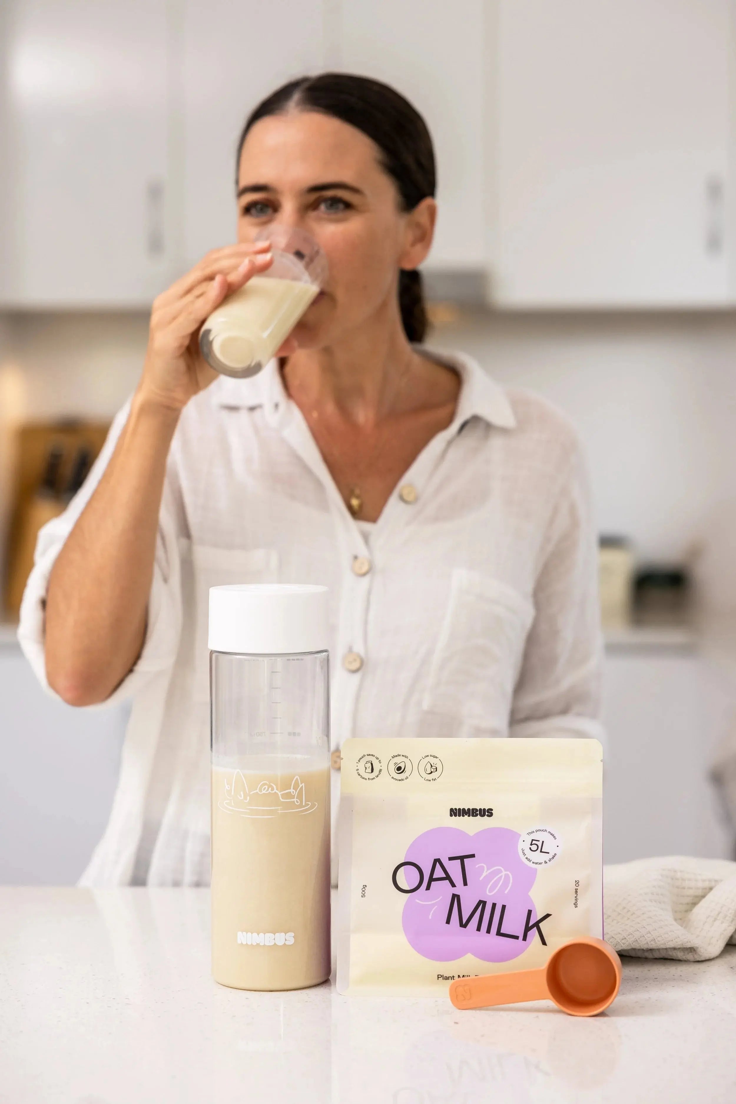 Prepared Nimbus oat milk with its powder pouch in a kitchen setting