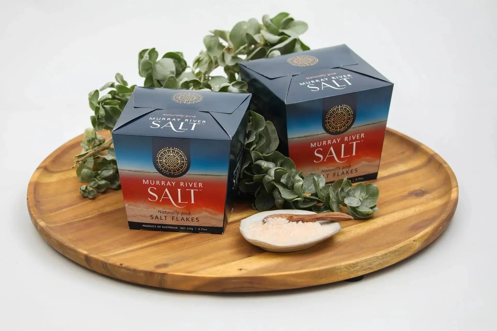 Murray River pink salt flakes styled with eucalyptus on a timber tray