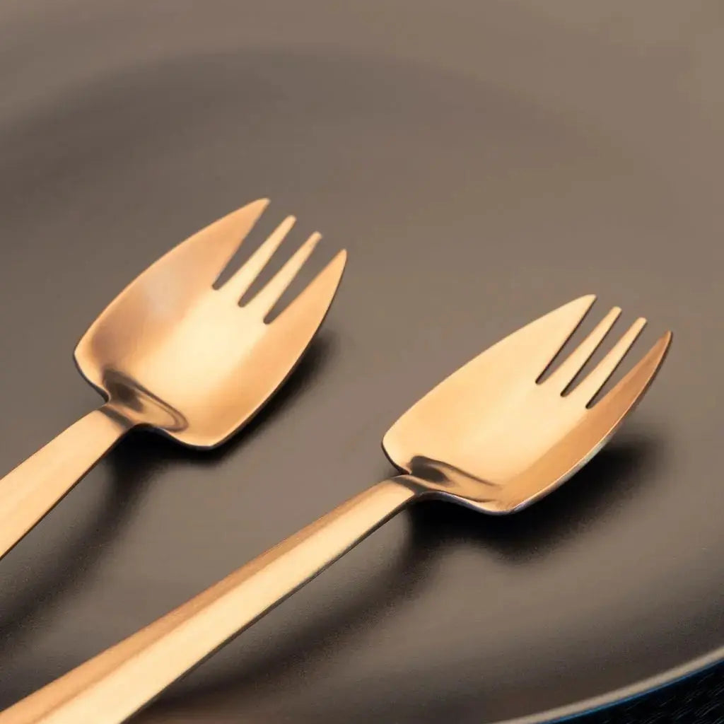 Rose-gold Splayd utensils arranged on a dark plate