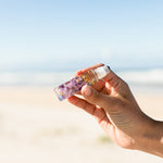 Summer Salt Sleep Essential Oil Roller — product held outdoors lifestyle image