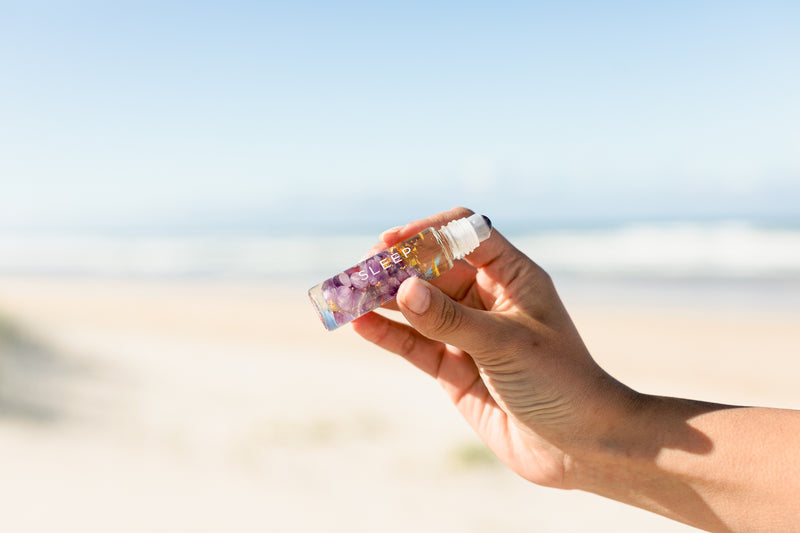 Summer Salt Sleep Essential Oil Roller — product held outdoors lifestyle image