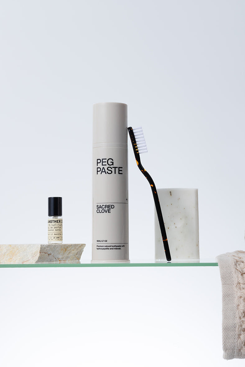 Peg Paste Sacred Clove toothpaste with toothbrush in a minimalist bathroom