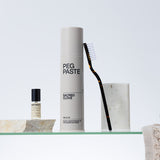 Peg Paste Sacred Clove toothpaste with toothbrush in a minimalist bathroom