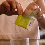 Sodii Salty Citrus electrolyte sachet being opened over a glass